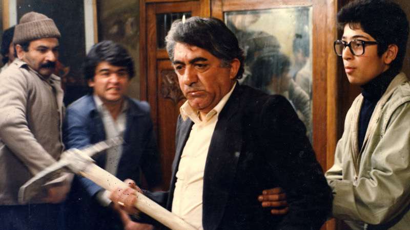 عزت‌الله انتظامی کلنگ به‌دست در صحنه‌ای از فیلم اجاره‌نشین‌ها