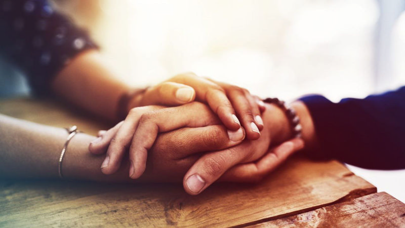 دست زنی که دست مردی را در دست گرفته و به او دلداری می‌دهد
