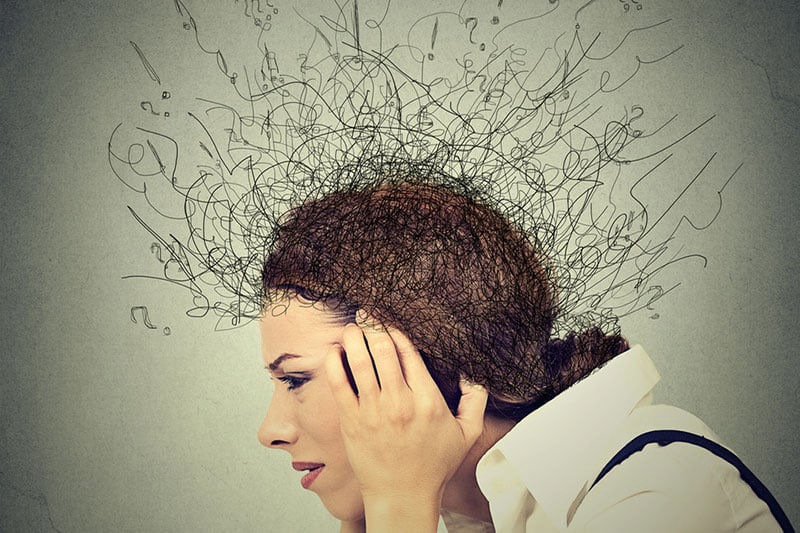 دختری که پیشانی‌اش را به‌خاطر استرس و اضطراب فشار می‌دهد