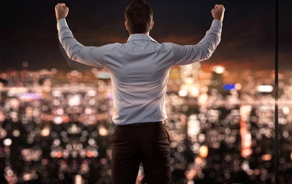 مردی که احساس پیروزی می‌کند و مشت‌های را به سمت هوا بلند کرده است