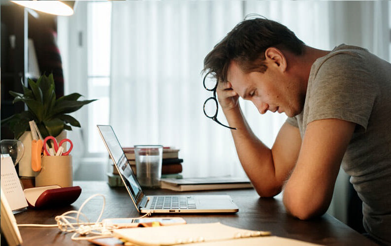 مردی که به دلیل فشار کاری زیاد دچار استرس و اضطراب شده و سرش را به دستش تکیه داده است