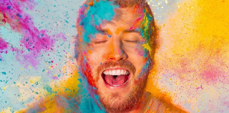 مردی شاد در میان پودرهای رنگی