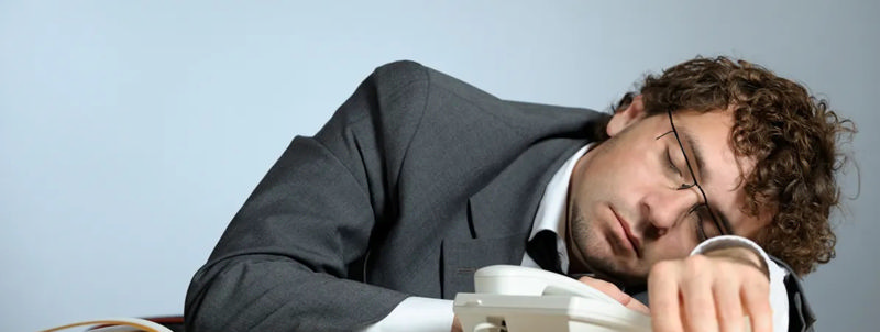 فرد تنبلی که سرش را روی میز گذاشته است