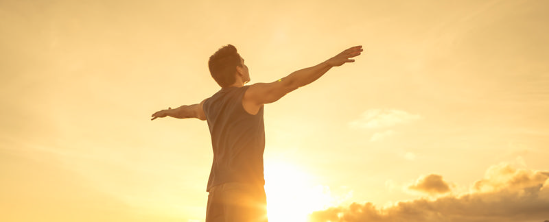 شخصی که دست‌هایش را در آفتاب به دو طرف گشوده و احساس سرزندگی میکند