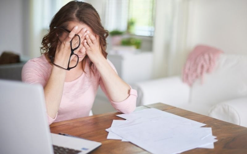 زنی با لباس صورتی که از کلافگی صورتش را پوشانده است