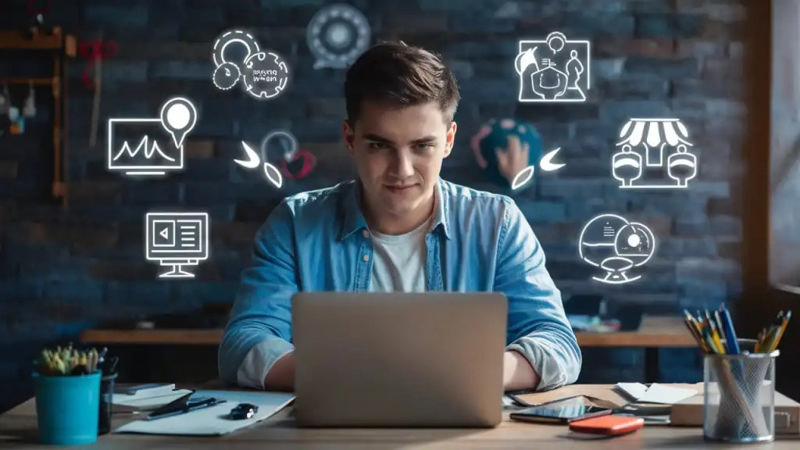 یک کارآفرین جوان که با لپ تاپ خودش کار می‌کند و تمرکز کرده است