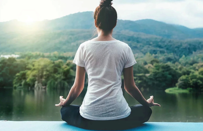 زنی در حال یوگا روبه‌روی رودخانه