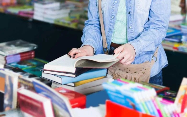 دست دختری در حال ورق زدن کتاب